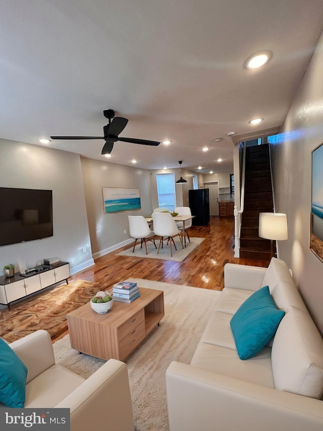 living room with hardwood / wood-style floors and ceiling fan