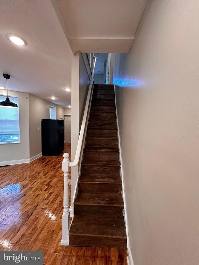 stairs featuring hardwood / wood-style floors