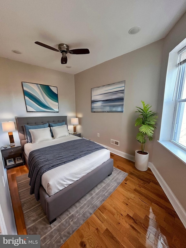 bedroom with ceiling fan and hardwood / wood-style flooring