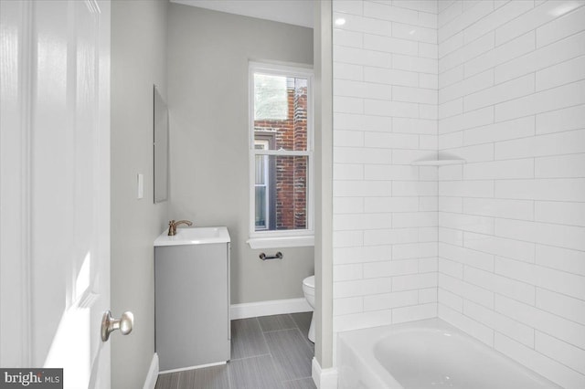 full bathroom featuring tile patterned floors, vanity, tiled shower / bath combo, and toilet