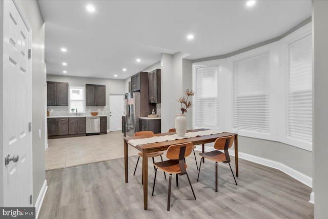 dining area with sink and light wood-type flooring