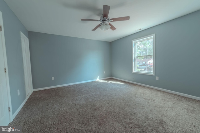 carpeted spare room with ceiling fan