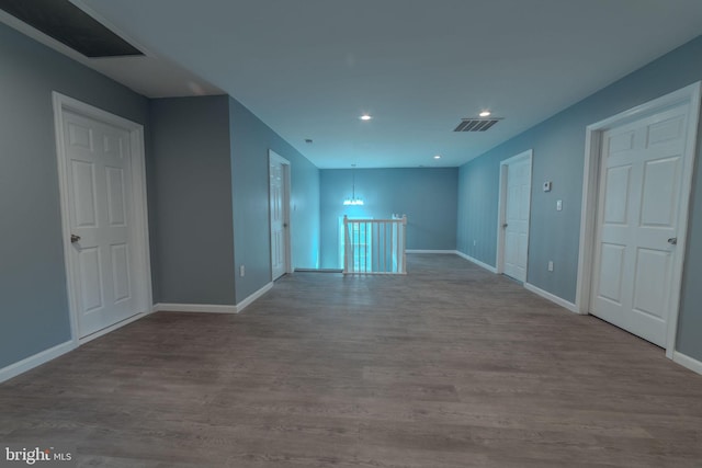 empty room with light hardwood / wood-style flooring and a notable chandelier