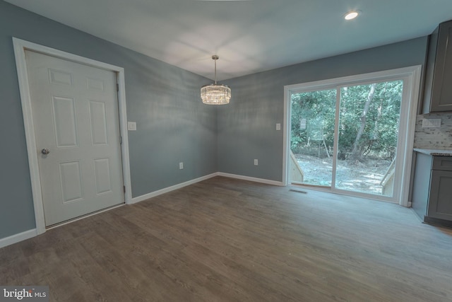 unfurnished dining area with a chandelier and light wood-type flooring