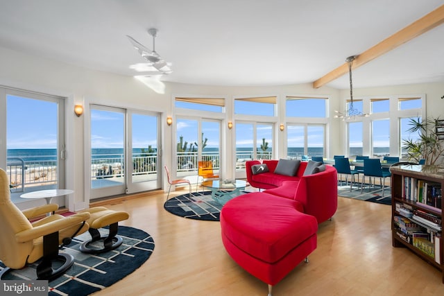 living room with a chandelier, a water view, plenty of natural light, and light hardwood / wood-style floors