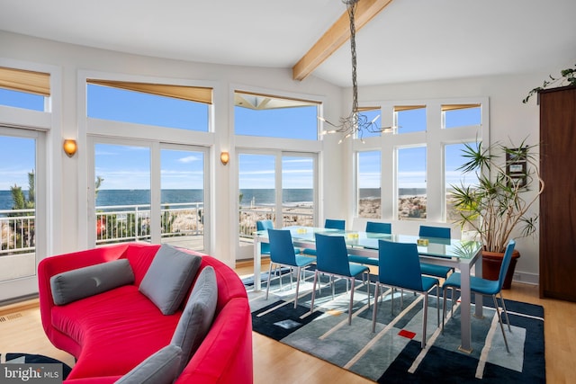 sunroom / solarium with vaulted ceiling with beams, a wealth of natural light, a water view, and an inviting chandelier