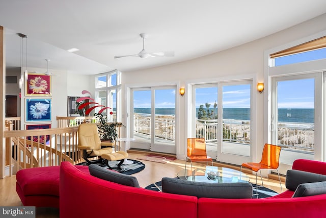 living room with hardwood / wood-style floors, ceiling fan, and a water view