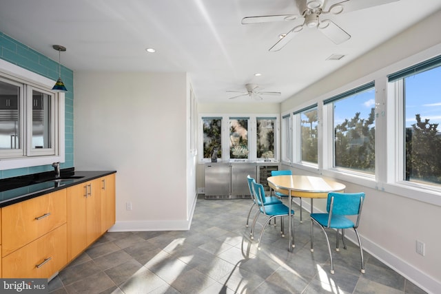 sunroom / solarium with ceiling fan and sink