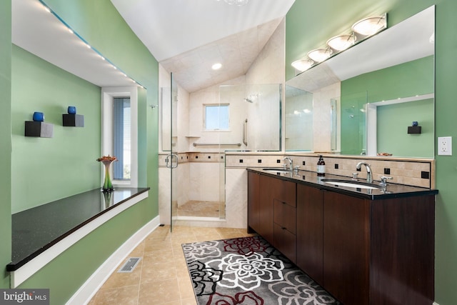 bathroom with tile patterned floors, vanity, a shower with shower door, and lofted ceiling