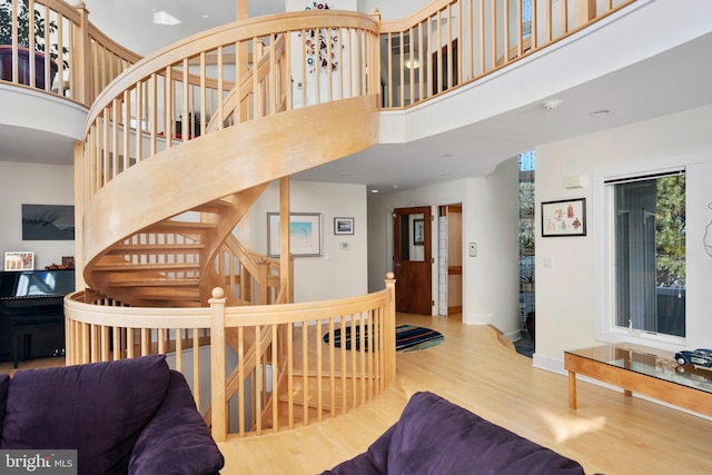 interior space featuring a towering ceiling and light hardwood / wood-style flooring