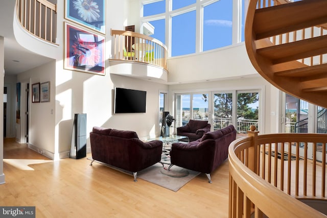 living room featuring a towering ceiling and light hardwood / wood-style floors