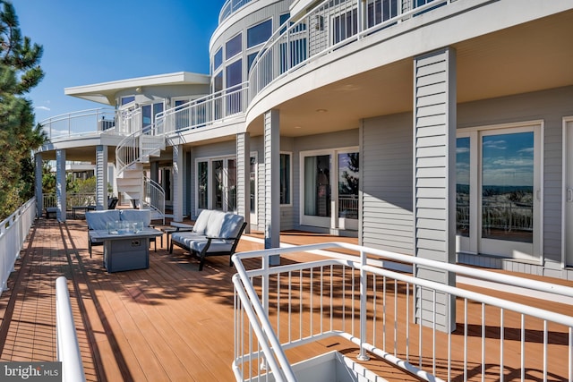 deck featuring an outdoor living space with a fire pit