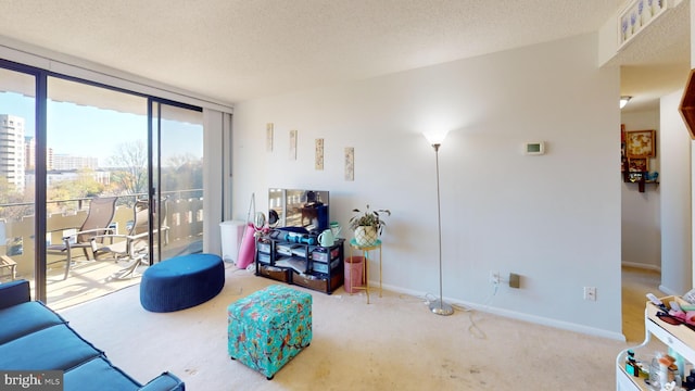 living room with carpet flooring, a textured ceiling, and a wall of windows