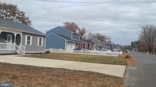 view of property exterior featuring covered porch, a garage, and a lawn