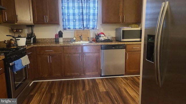 kitchen with sink, dark wood-type flooring, extractor fan, and appliances with stainless steel finishes