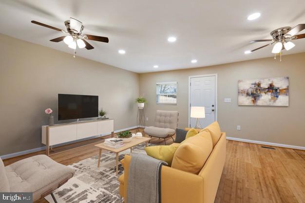 living room with ceiling fan and light wood-type flooring