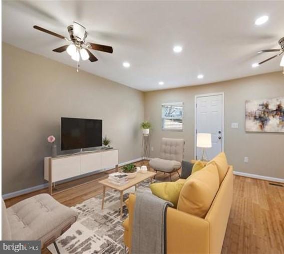 living room featuring ceiling fan and light hardwood / wood-style flooring