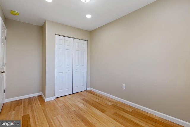 unfurnished bedroom featuring a closet and light hardwood / wood-style floors