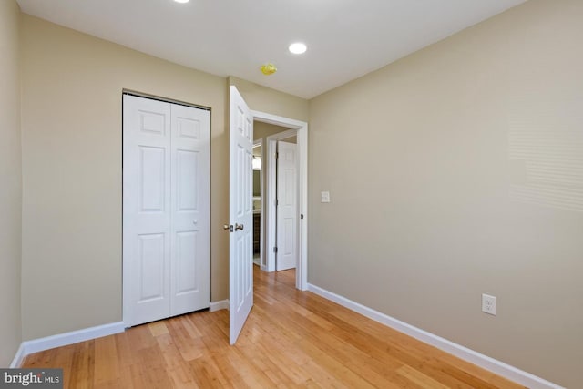 unfurnished bedroom with a closet and light hardwood / wood-style flooring