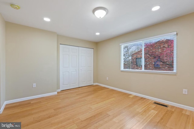 unfurnished bedroom featuring a closet and light hardwood / wood-style flooring