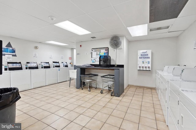 laundry area with washing machine and clothes dryer and light tile patterned flooring