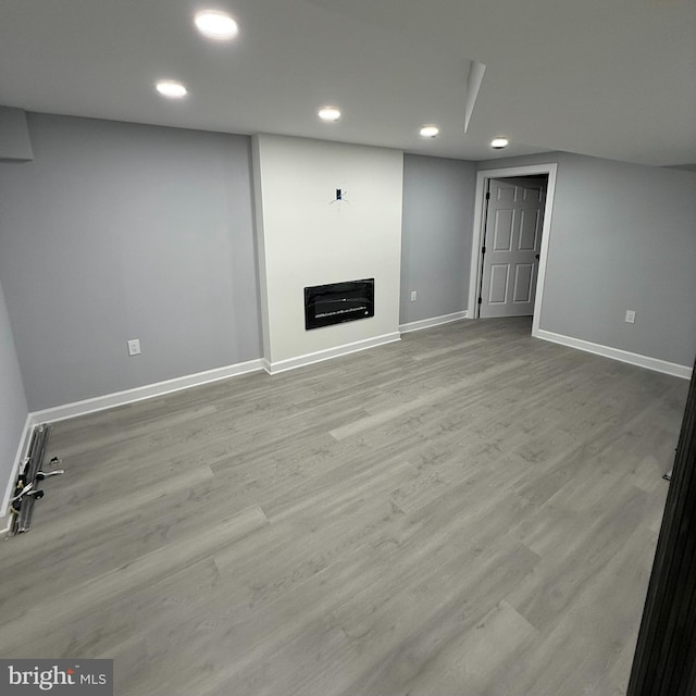 basement with light hardwood / wood-style flooring