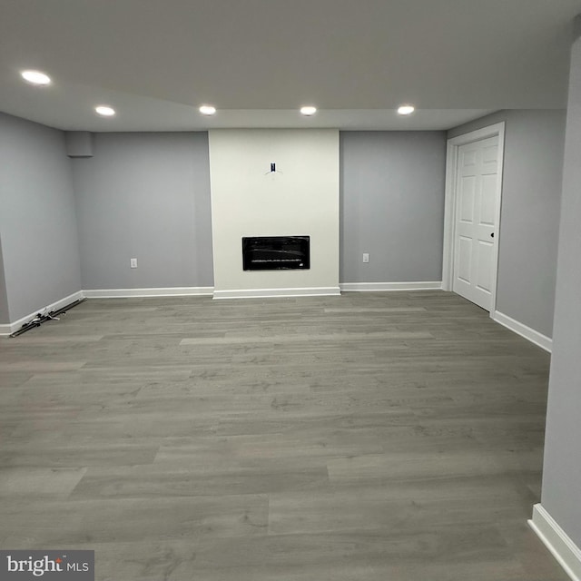 basement with light hardwood / wood-style flooring