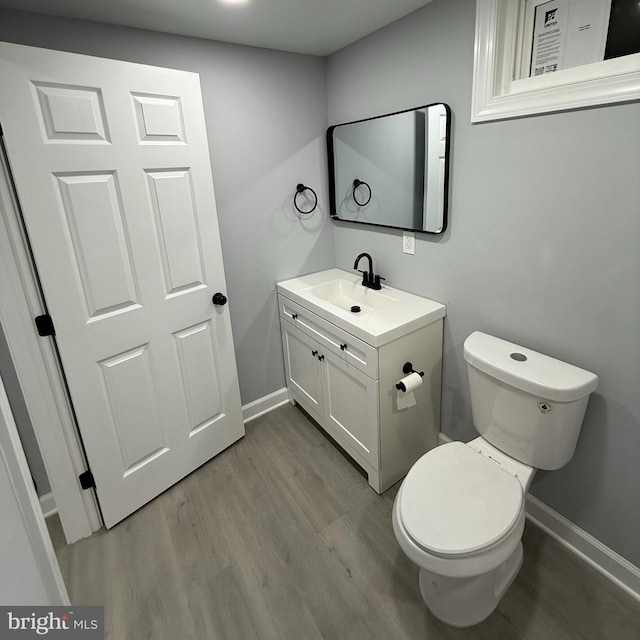 bathroom with hardwood / wood-style floors, toilet, and vanity