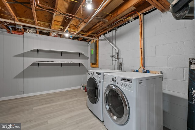 laundry room with light wood-type flooring, electric panel, and independent washer and dryer