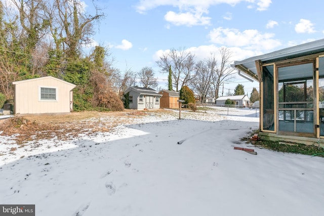 yard layered in snow with a shed