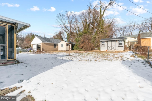 yard covered in snow featuring a storage shed