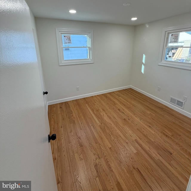 spare room featuring light hardwood / wood-style flooring and a wealth of natural light