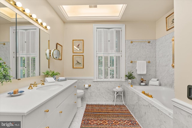 bathroom with a skylight, tile patterned floors, vanity, a relaxing tiled tub, and tile walls