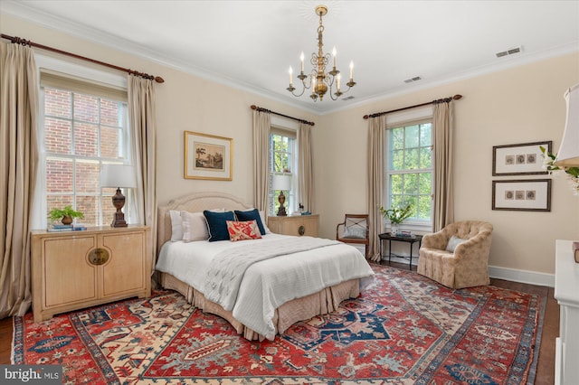 bedroom with crown molding, wood-type flooring, and an inviting chandelier