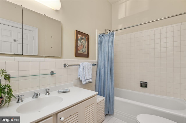 full bathroom with shower / tub combo, tile patterned floors, toilet, vanity, and tile walls