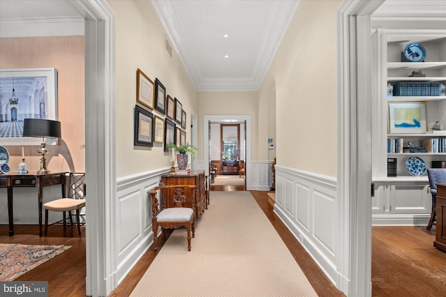 corridor featuring hardwood / wood-style flooring, built in shelves, and crown molding