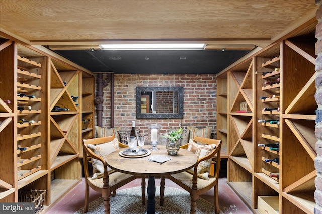 wine room with brick wall and wood ceiling