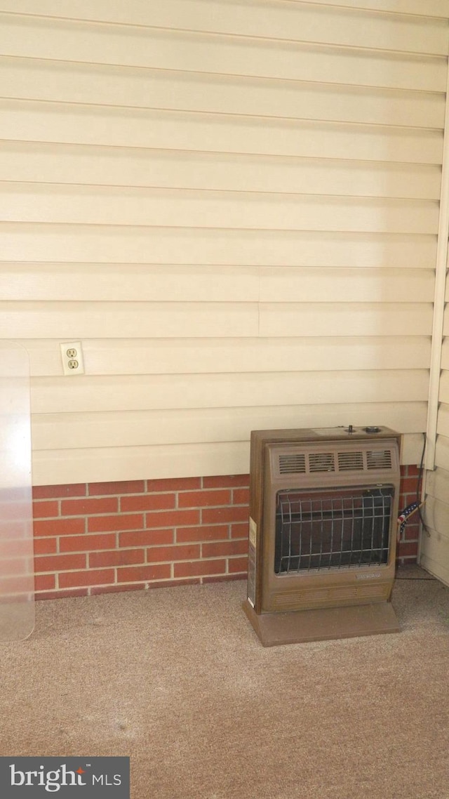 details featuring a wood stove, carpet flooring, and heating unit