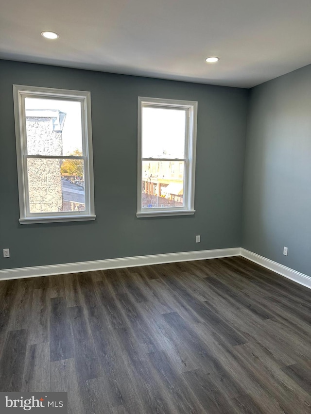 unfurnished room with dark wood-type flooring