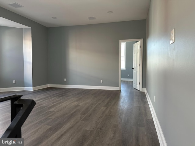 unfurnished room with dark wood-type flooring