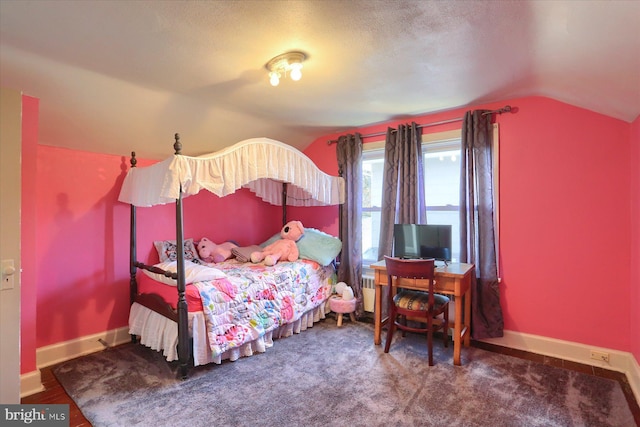 carpeted bedroom with a textured ceiling and vaulted ceiling