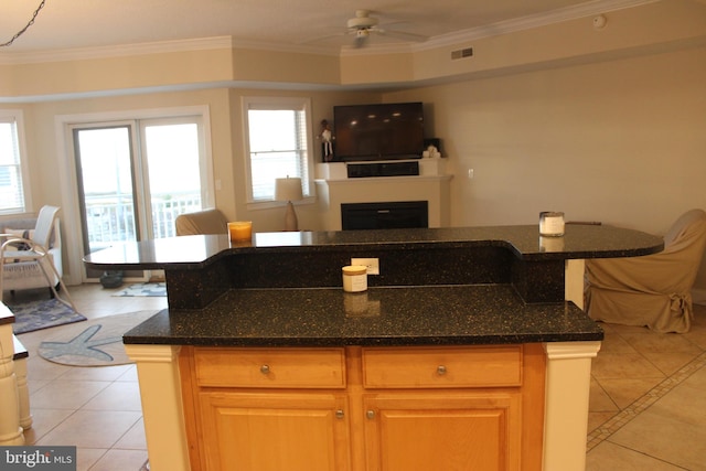 kitchen with ceiling fan, light tile patterned floors, ornamental molding, and a wealth of natural light