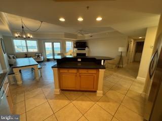 kitchen with a kitchen island, light tile patterned floors, and an inviting chandelier