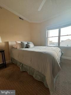 bedroom with dark colored carpet, ceiling fan, and ornamental molding