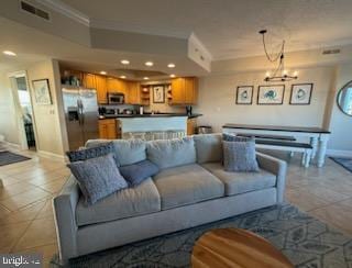 living room featuring crown molding, light tile patterned floors, and an inviting chandelier