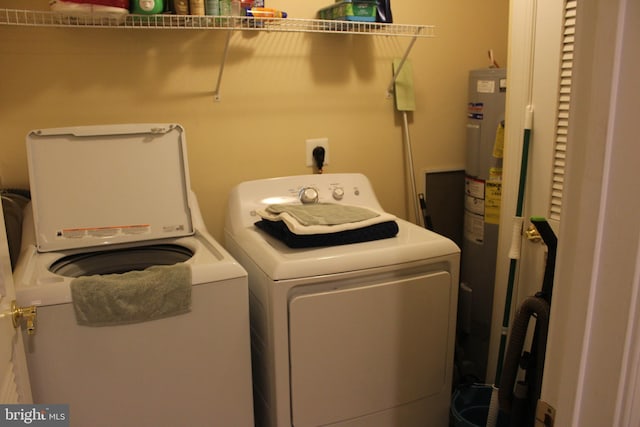 clothes washing area with separate washer and dryer and electric water heater