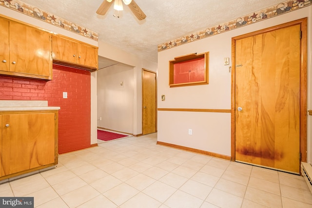 kitchen featuring a baseboard radiator, ceiling fan, light tile patterned floors, and a textured ceiling