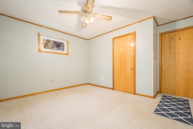 unfurnished bedroom featuring a closet, light colored carpet, ceiling fan, and ornamental molding