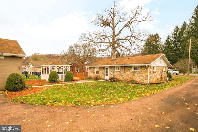 back of property with a gazebo, a yard, and a wooden deck