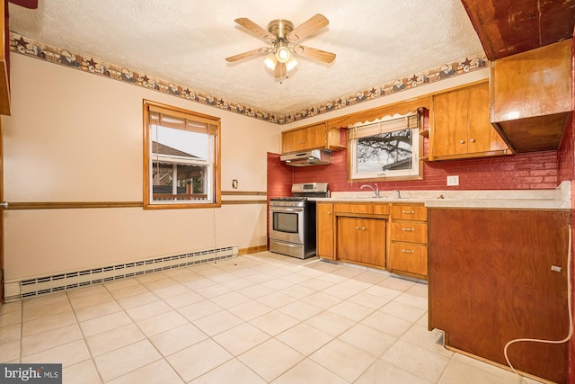 kitchen featuring a textured ceiling, ceiling fan, a baseboard heating unit, light tile patterned floors, and stainless steel stove